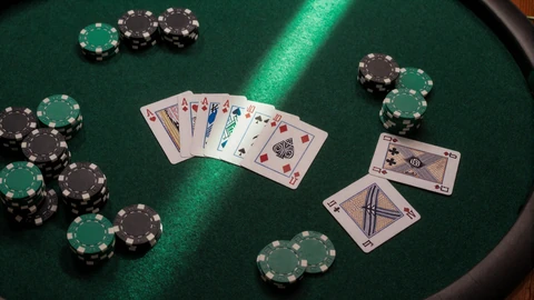 Pokerchips und Spielkarten auf gr&uuml;nem Filz mit Spotlight-Strahl f&uuml;r Golisimo Reload-Bonus